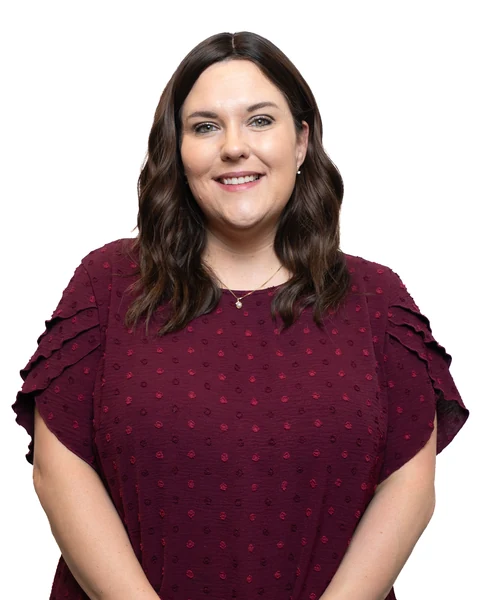 Professional headshot at the Clark Insurance office opening, Magnolia, TX: woman in a burgundy polka-dot blouse