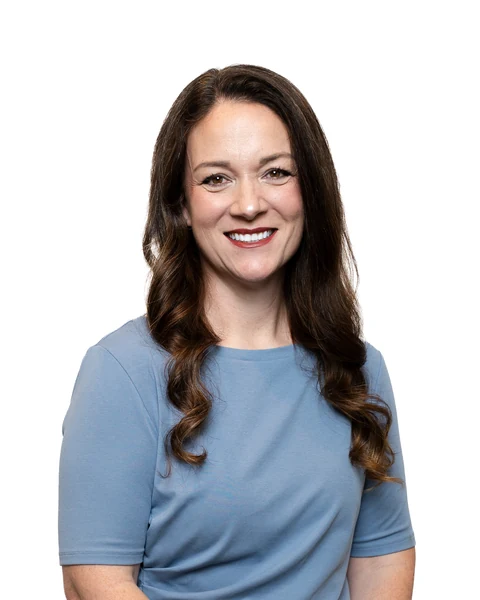 Professional headshot at the Clark Insurance office opening, Magnolia, TX: woman with long brown hair in a light blue top