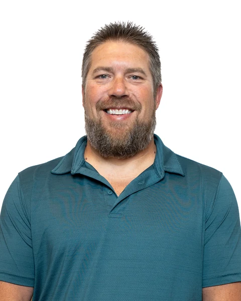 Professional headshot at the Clark Insurance office opening, Magnolia, TX: man with a beard in a teal polo