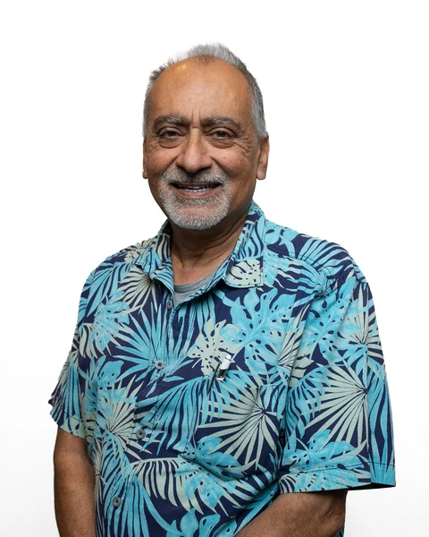 Professional headshot at the Clark Insurance office opening, Magnolia, TX: man with gray hair and beard in a teal tropical-print shirt