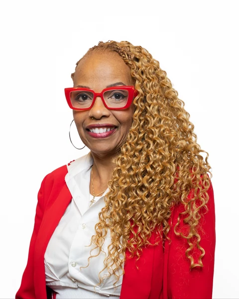 Professional headshot at the Clark Insurance office opening, Magnolia, TX: woman with red glasses in a red blazer