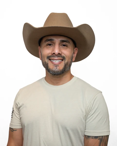 Professional headshot at the Clark Insurance office opening, Magnolia, TX: man in a tan cowboy hat and beige T-shirt