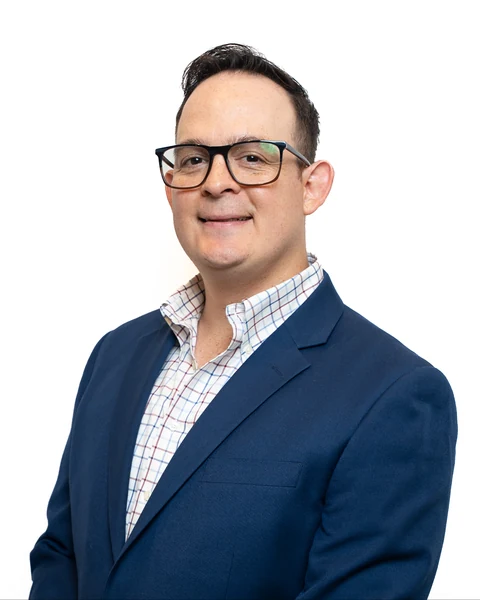 Professional headshot at the Clark Insurance office opening, Magnolia, TX: man with glasses in a navy blazer